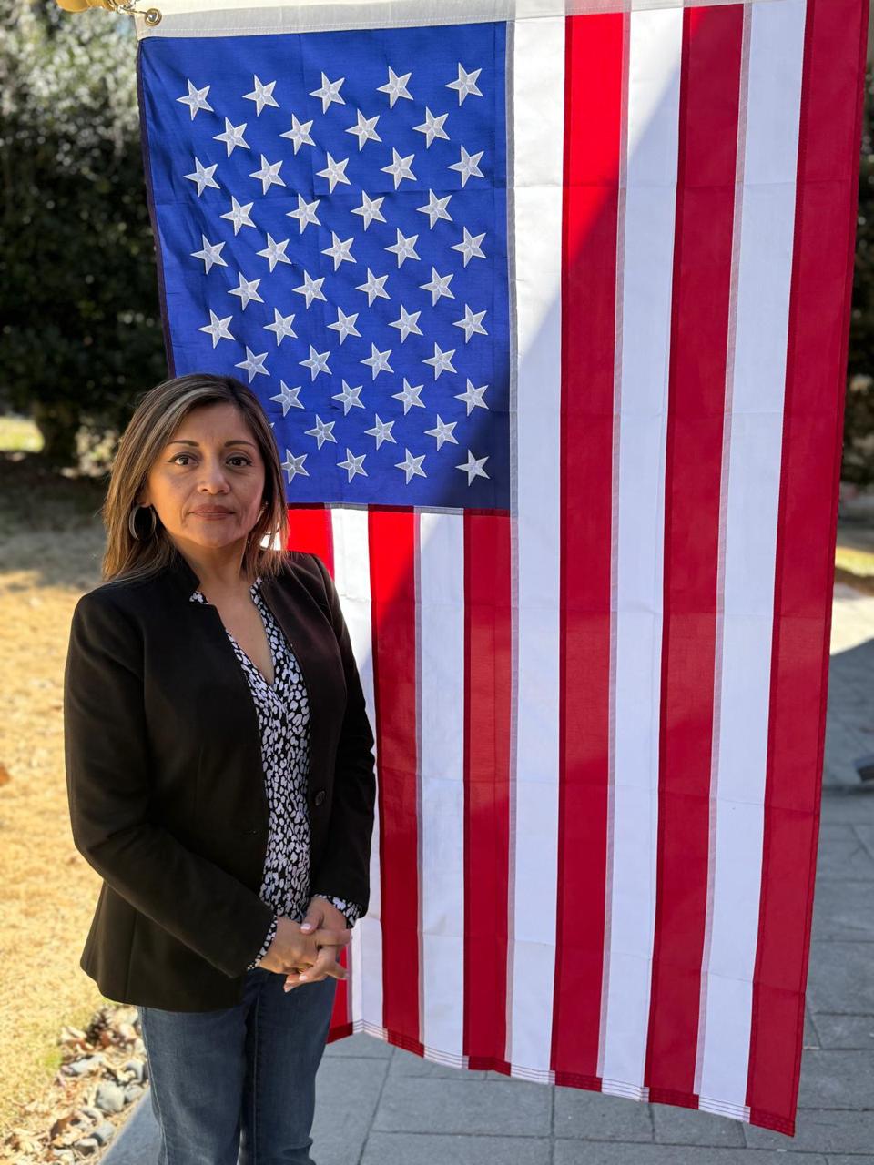 Gianina Sandoval, fundadora de ASA Immigration Services, frente a la bandera de Estados Unidos